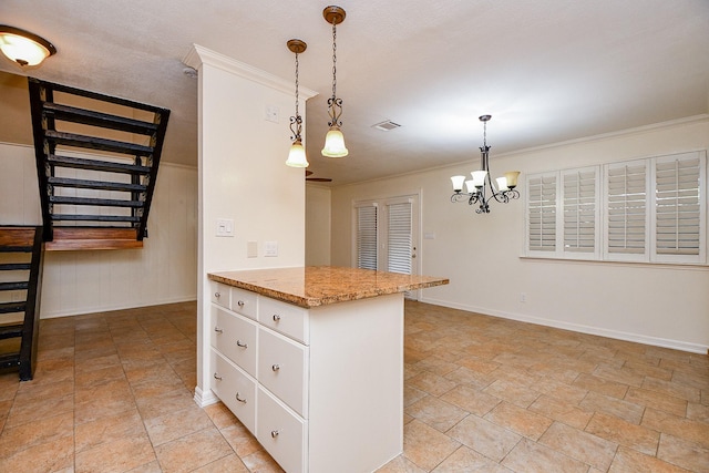 kitchen with light stone countertops, a chandelier, baseboards, pendant lighting, and white cabinets