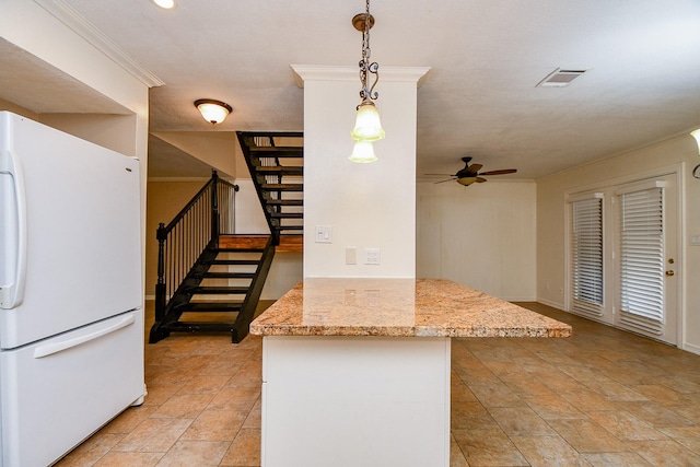 kitchen featuring a ceiling fan, visible vents, decorative light fixtures, a peninsula, and freestanding refrigerator