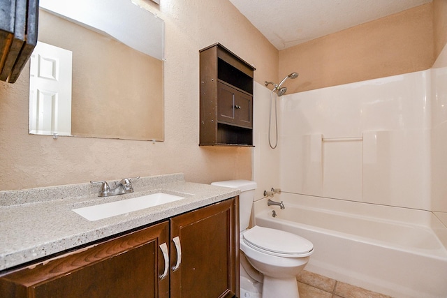 bathroom with tile patterned floors, vanity, tub / shower combination, a textured wall, and toilet