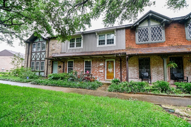 view of front of home featuring a front lawn and brick siding