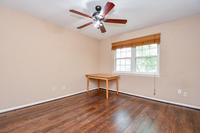 spare room featuring wood finished floors, ceiling fan, and baseboards