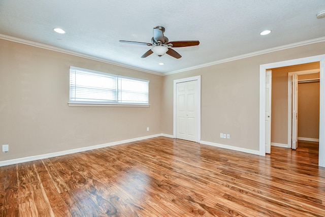 unfurnished bedroom with wood finished floors, a closet, ornamental molding, and baseboards