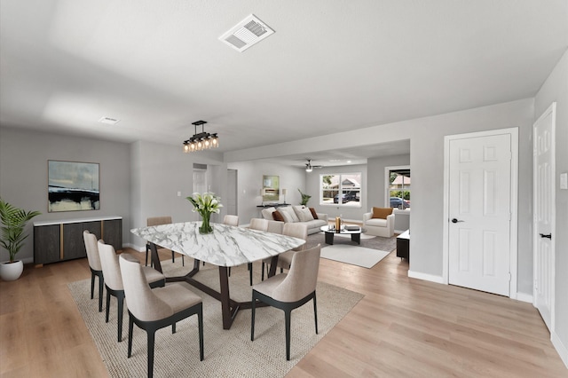 dining area featuring light wood-style floors, visible vents, a ceiling fan, and baseboards