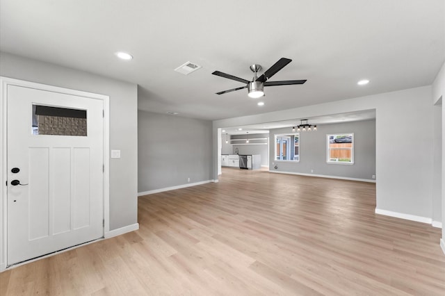 unfurnished living room with ceiling fan with notable chandelier, baseboards, recessed lighting, and light wood-style floors