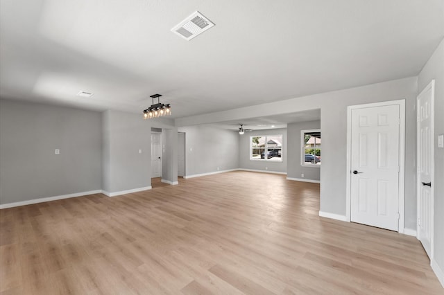 unfurnished living room with baseboards, a ceiling fan, light wood finished floors, and visible vents