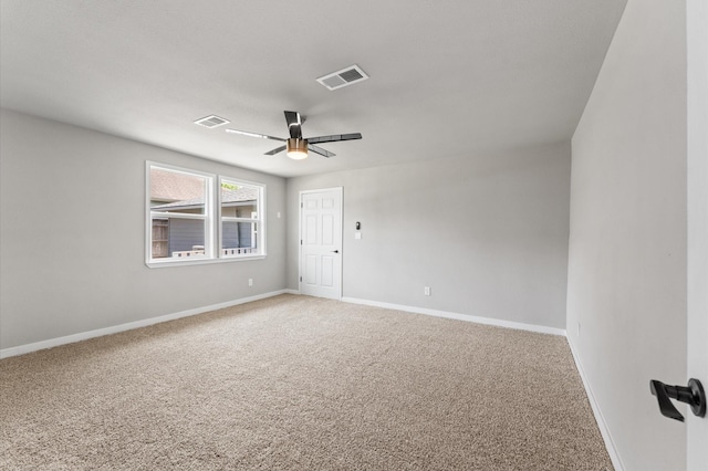 empty room with visible vents, carpet flooring, baseboards, and ceiling fan