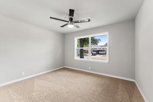 unfurnished room with carpet floors, a ceiling fan, and baseboards