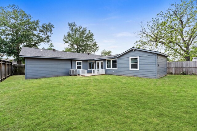 back of house with a fenced backyard, central air condition unit, and a lawn