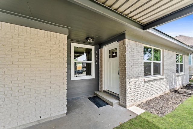view of exterior entry with brick siding