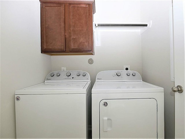 laundry room featuring washing machine and clothes dryer and cabinet space