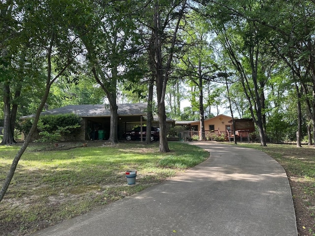 ranch-style house featuring aphalt driveway and a front yard