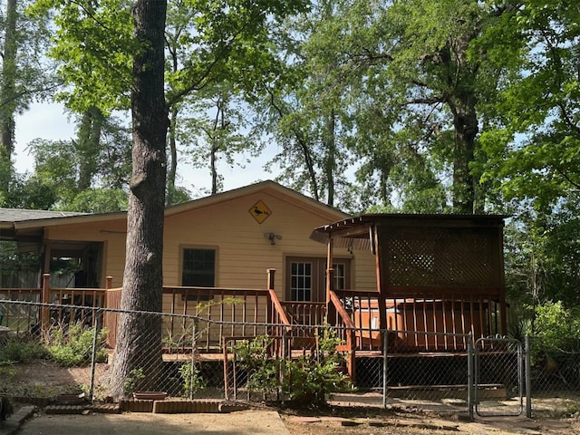 back of house with a wooden deck, fence, and a gate