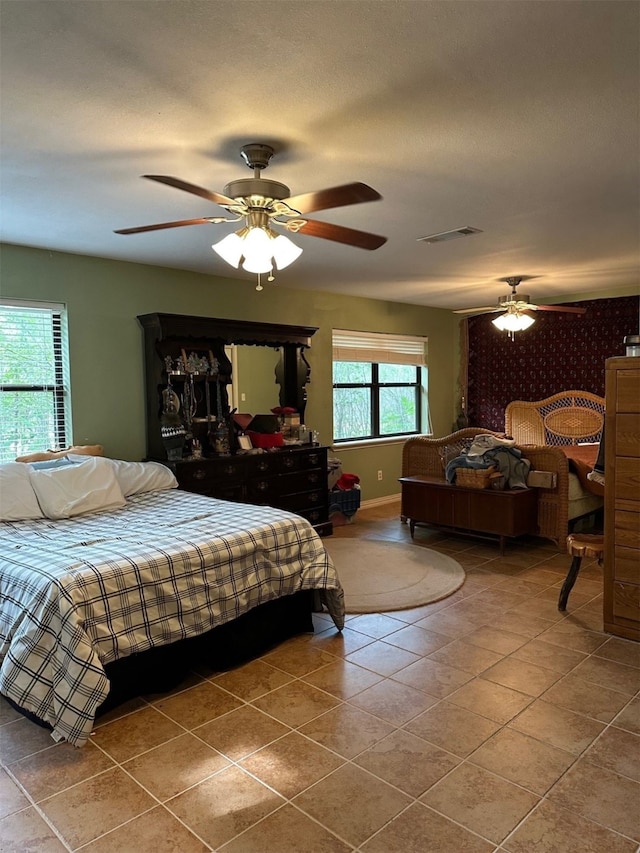 bedroom featuring a ceiling fan, visible vents, and tile patterned flooring