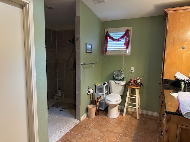 full bath with toilet, vanity, tile patterned floors, and tiled shower