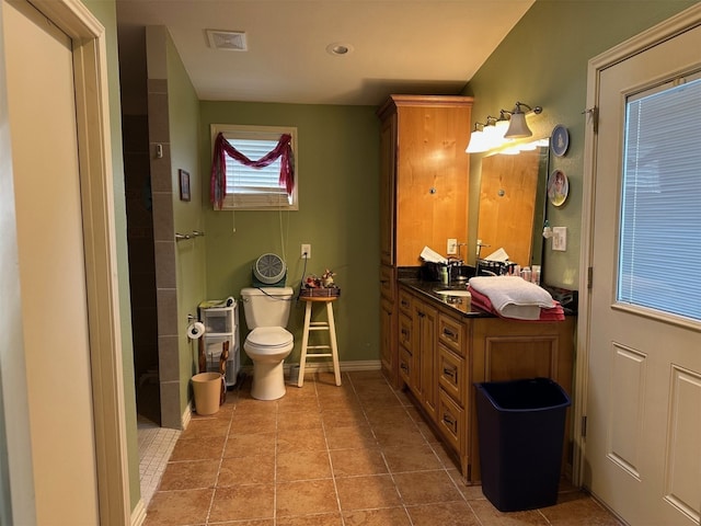 full bath with visible vents, toilet, vanity, baseboards, and a shower