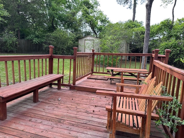 deck with a lawn, an outbuilding, and a shed