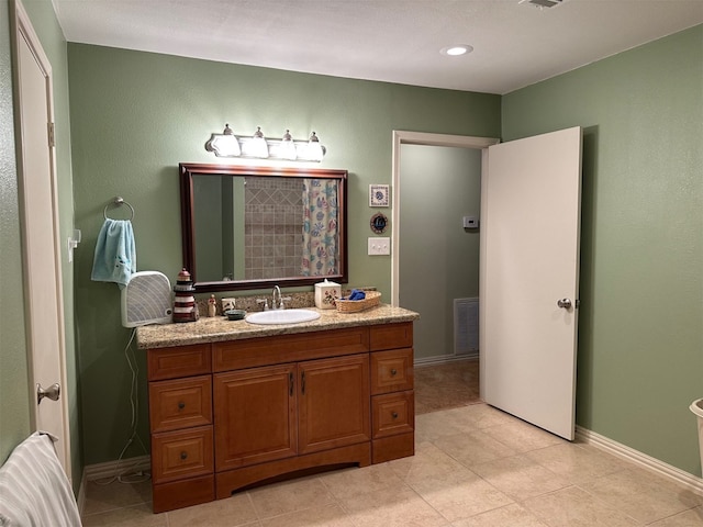 bathroom with baseboards, visible vents, tile patterned flooring, and vanity