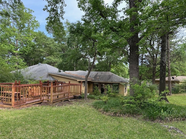 back of house with a wooden deck and a lawn