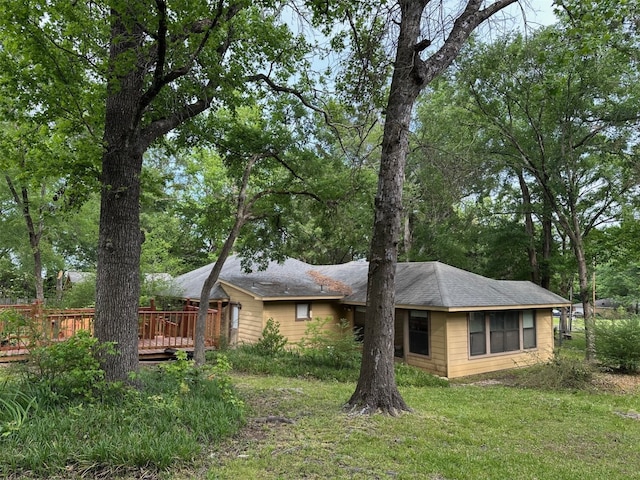 rear view of house featuring a yard and a deck