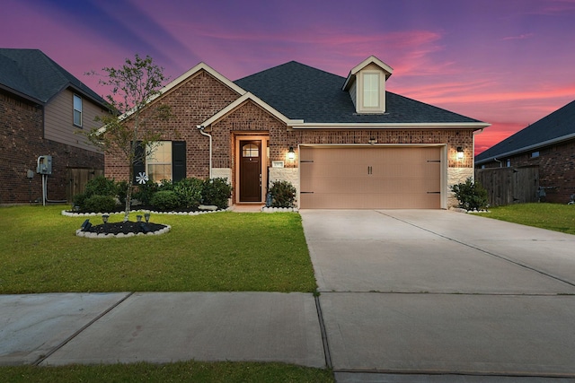 view of front facade with brick siding, a yard, an attached garage, and concrete driveway