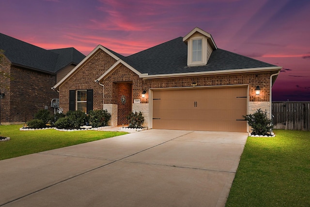 view of front of house featuring brick siding, an attached garage, driveway, and a lawn