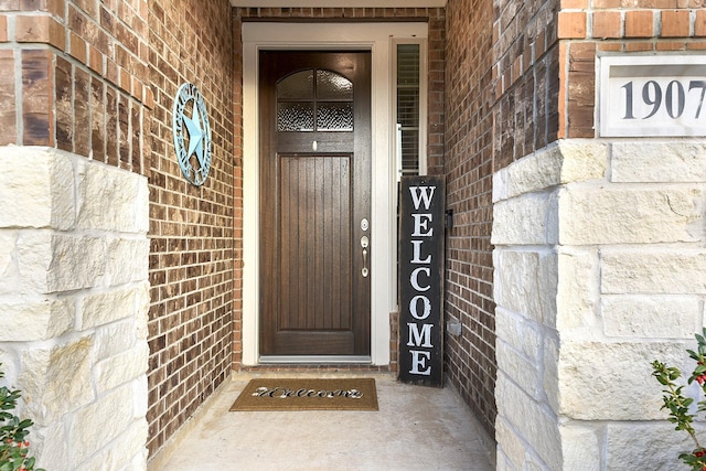 entrance to property featuring brick siding
