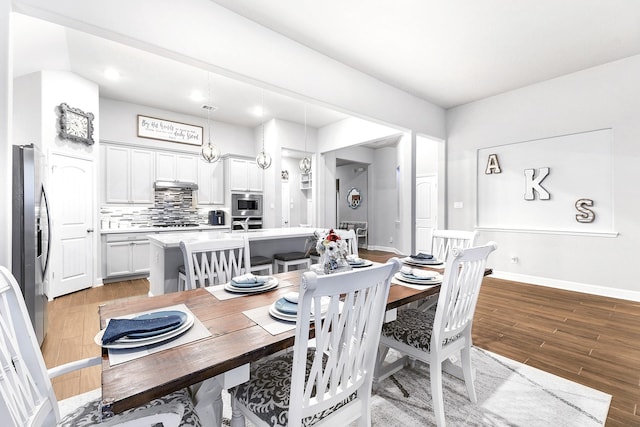 dining space featuring baseboards, light wood-style floors, and recessed lighting