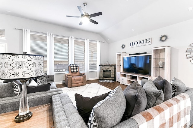 living area featuring ceiling fan, vaulted ceiling, wood finished floors, and baseboards