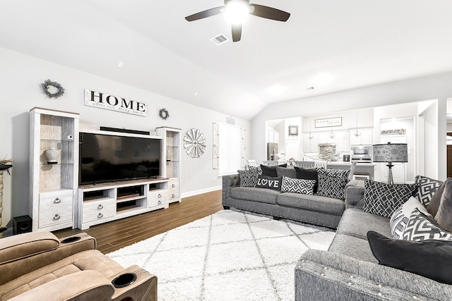 living room featuring vaulted ceiling, wood finished floors, ceiling fan, baseboards, and visible vents