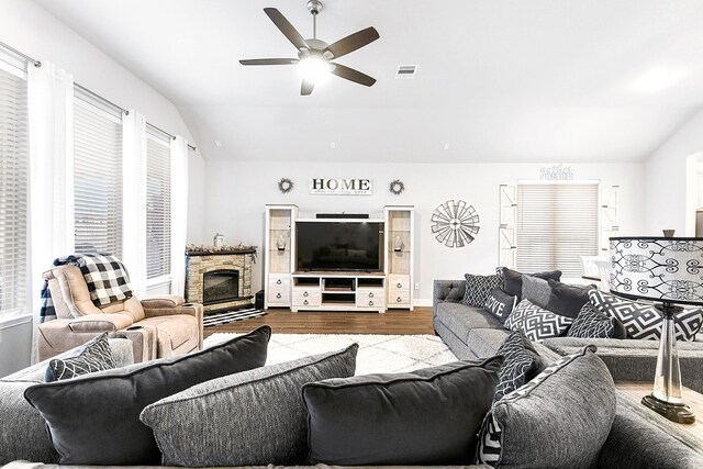 living area with vaulted ceiling, a wealth of natural light, dark wood-type flooring, and ceiling fan
