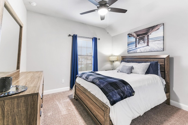 carpeted bedroom featuring lofted ceiling, baseboards, and ceiling fan