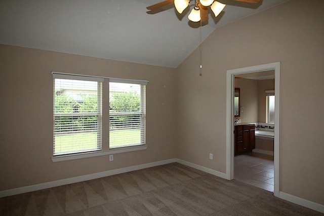 spare room featuring baseboards, a ceiling fan, lofted ceiling, and light carpet