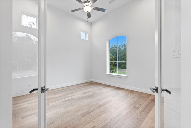 unfurnished room featuring french doors, light wood-type flooring, baseboards, visible vents, and a ceiling fan