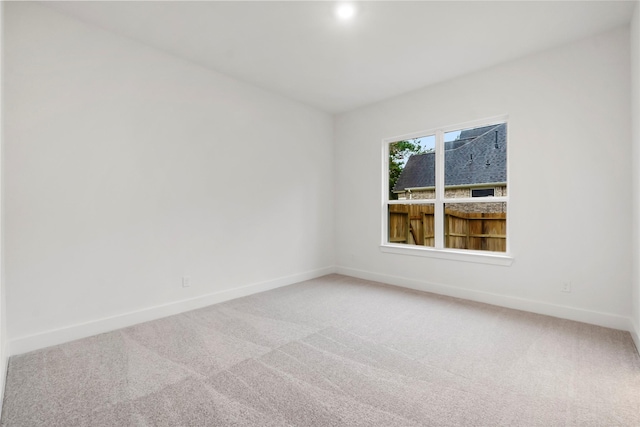 carpeted spare room with baseboards