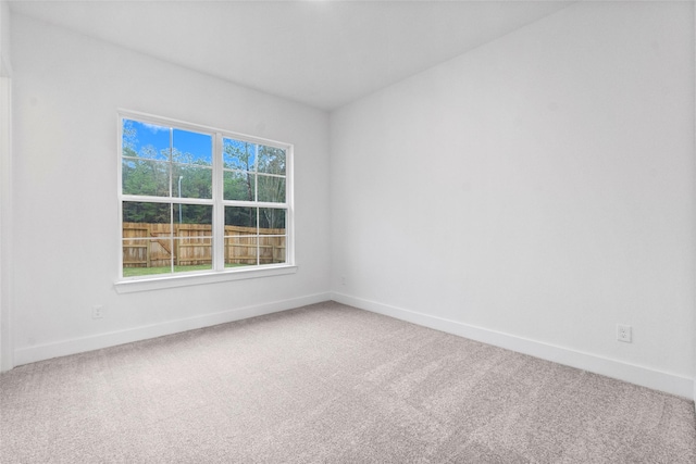 carpeted spare room featuring baseboards