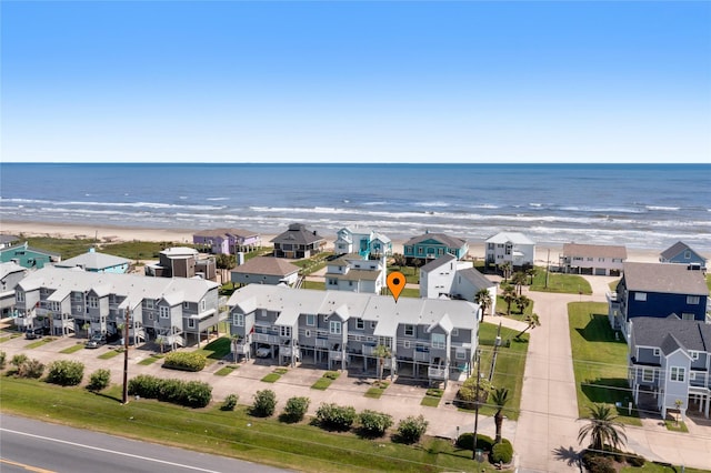 drone / aerial view featuring a view of the beach, a water view, and a residential view