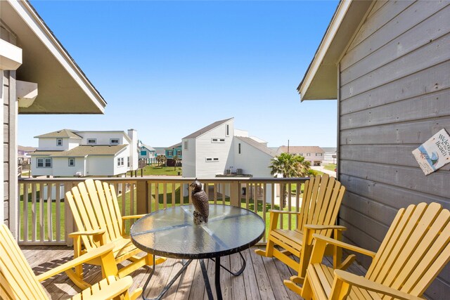 deck with outdoor dining area and a residential view