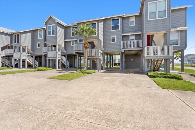 exterior space with a carport, driveway, and stairs