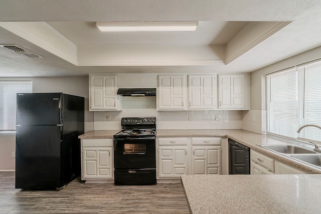 kitchen featuring visible vents, white cabinetry, extractor fan, wood finished floors, and black appliances