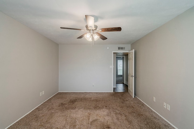 empty room with visible vents, baseboards, a ceiling fan, and carpet floors