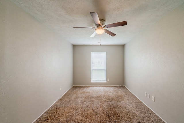 empty room with carpet flooring, ceiling fan, and a textured ceiling