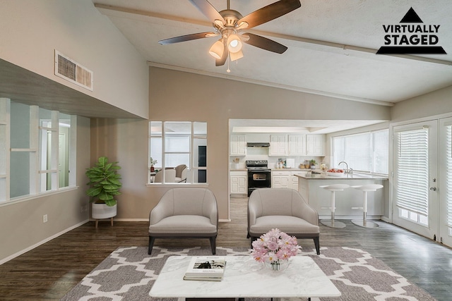 interior space featuring baseboards, wood finished floors, visible vents, and vaulted ceiling