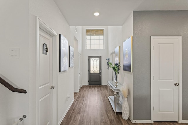 doorway with dark wood-type flooring and baseboards