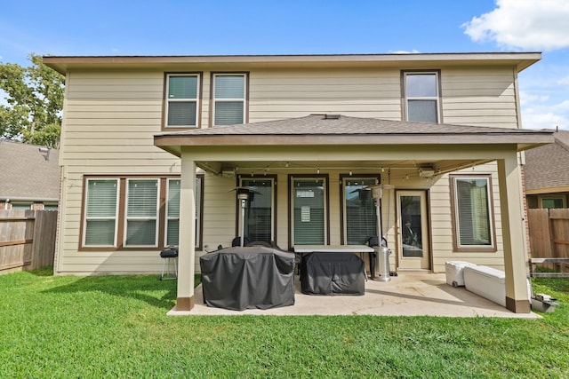 back of property with a fenced backyard, a yard, and a patio