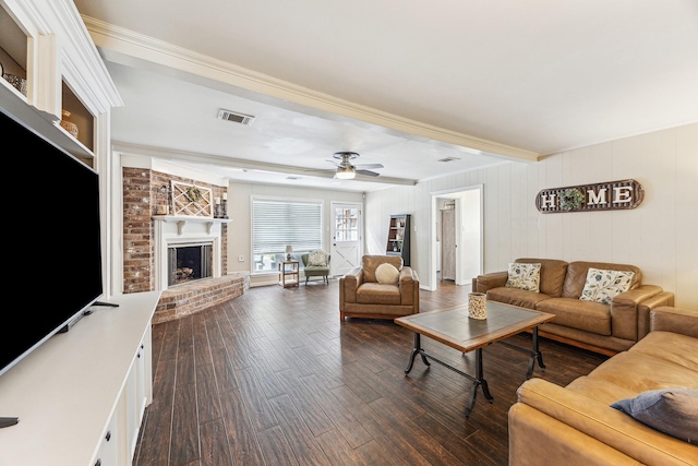 living room with dark wood-style flooring, a fireplace, beam ceiling, visible vents, and crown molding