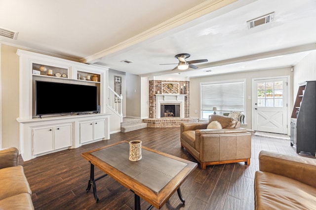living room featuring dark wood finished floors, visible vents, ornamental molding, and ceiling fan