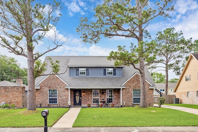 traditional home featuring fence, roof with shingles, a front yard, and brick siding