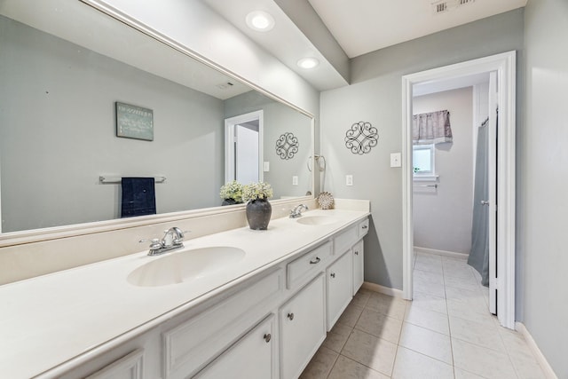bathroom with recessed lighting, tile patterned flooring, double vanity, and a sink