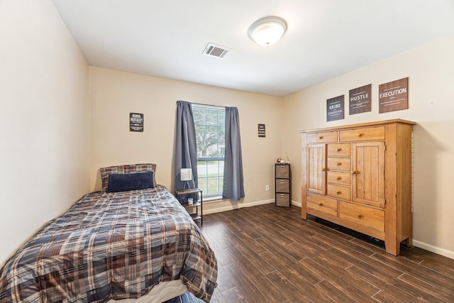 bedroom with visible vents, baseboards, and dark wood finished floors