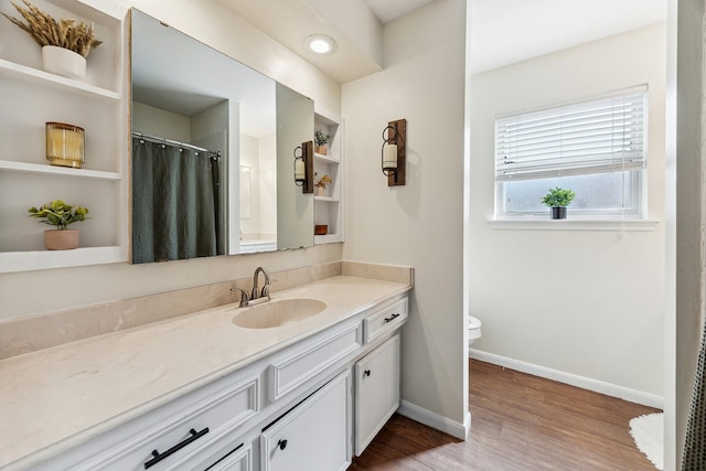 bathroom featuring wood finished floors, a shower with shower curtain, toilet, vanity, and baseboards
